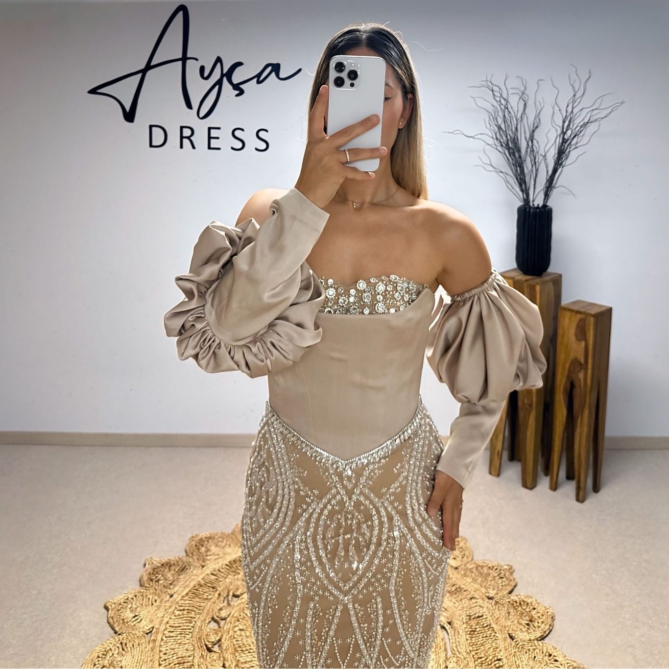 Ayça Dress - Eleganz in Beige Model in einem eleganten, beigen Kleid mit voluminösen Pufferärmeln. Das Kleid hat feine Perlen-Details und einen fließenden Stoff.